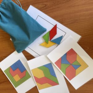 matériel posé sur une table contenant 60 pièces, 3 figures, 3, 1 cadre pour la reproduction de 3 figures du discrikolor afin d'améliorer les fondations cognitives des apprentissages scolaires par le jeu